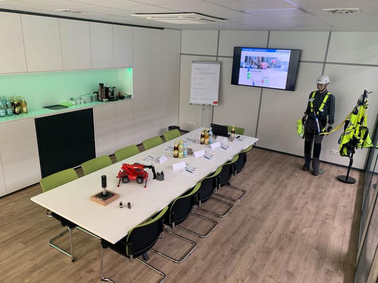 Gräber Training room equipped with chairs, a long table, screen, flipchart and personal protective equipment.